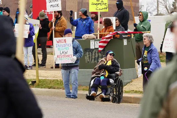 Madison, Wisconsin ABD - 29 Mart 2025: Liberal Demokratlar, Tesla Takedown ulusal etkinliği sırasında Tesla bayilik galerisi önündeki büyük bir gruptaki pankartlarla protesto ettiler.