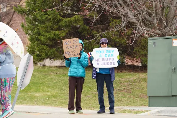 Madison, Wisconsin ABD - 29 Mart 2025: Liberal Demokratlar, Tesla Takedown ulusal etkinliği sırasında Tesla bayilik galerisi önündeki büyük bir gruptaki pankartlarla protesto ettiler.
