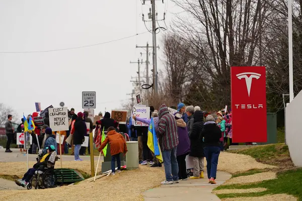 Madison, Wisconsin ABD - 29 Mart 2025: Liberal Demokratlar, Tesla Takedown ulusal etkinliği sırasında Tesla bayilik galerisi önündeki büyük bir gruptaki pankartlarla protesto ettiler.