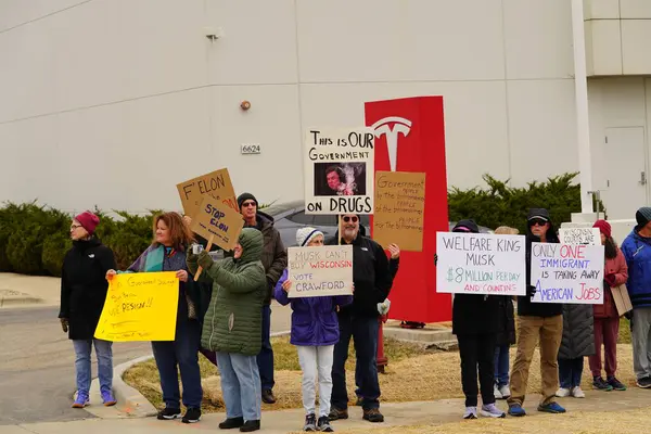 Madison, Wisconsin ABD - 29 Mart 2025: Liberal Demokratlar, Tesla Takedown ulusal etkinliği sırasında Tesla bayilik galerisi önündeki büyük bir gruptaki pankartlarla protesto ettiler.