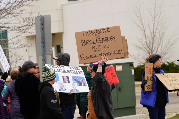 Madison, Wisconsin ABD - 29 Mart 2025: Liberal Demokratlar, Tesla Takedown ulusal etkinliği sırasında Tesla bayilik galerisi önündeki büyük bir gruptaki pankartlarla protesto ettiler.