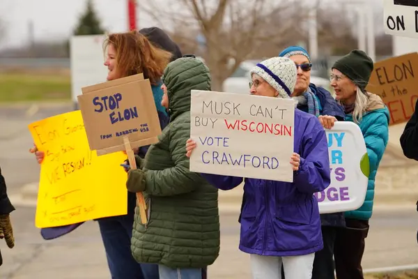Madison, Wisconsin ABD - 29 Mart 2025: Liberal Demokratlar, Tesla Takedown ulusal etkinliği sırasında Tesla bayilik galerisi önündeki büyük bir gruptaki pankartlarla protesto ettiler.