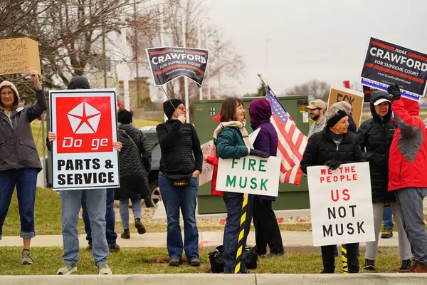 Madison, Wisconsin ABD - 29 Mart 2025: Liberal Demokratlar, Tesla Takedown ulusal etkinliği sırasında Tesla bayilik galerisi önündeki büyük bir gruptaki pankartlarla protesto ettiler.