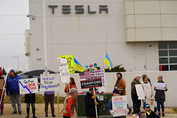 Madison, Wisconsin ABD - 29 Mart 2025: Liberal Demokratlar, Tesla Takedown ulusal etkinliği sırasında Tesla bayilik galerisi önündeki büyük bir gruptaki pankartlarla protesto ettiler.