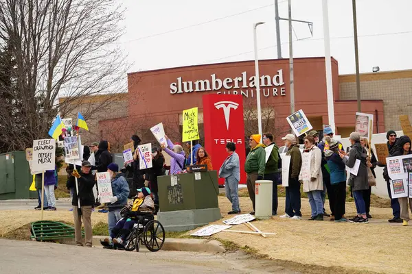 Madison, Wisconsin ABD - 29 Mart 2025: Liberal Demokratlar, Tesla Takedown ulusal etkinliği sırasında Tesla bayilik galerisi önündeki büyük bir gruptaki pankartlarla protesto ettiler.