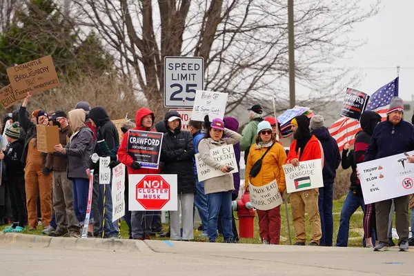 Madison, Wisconsin ABD - 29 Mart 2025: Liberal Demokratlar, Tesla Takedown ulusal etkinliği sırasında Tesla bayilik galerisi önündeki büyük bir gruptaki pankartlarla protesto ettiler.