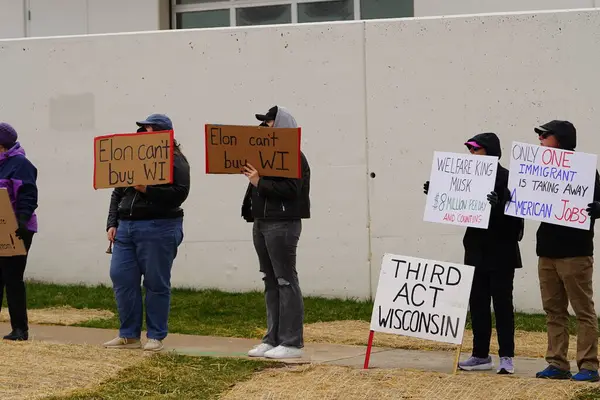 Madison, Wisconsin ABD - 29 Mart 2025: Liberal Demokratlar, Tesla Takedown ulusal etkinliği sırasında Tesla bayilik galerisi önündeki büyük bir gruptaki pankartlarla protesto ettiler.
