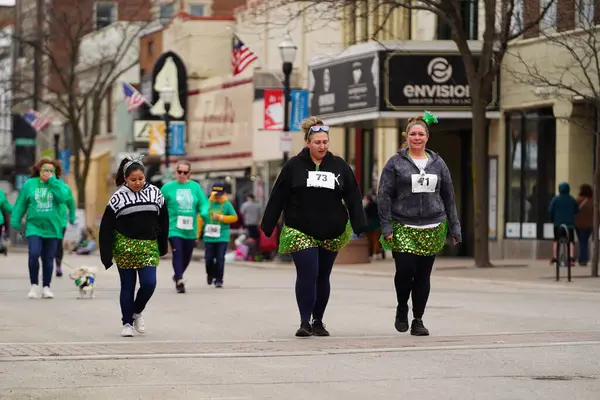 Fond du Lac, Wisconsin ABD - 15 Mart 2025: Cemaat üyeleri ve Yerel Örgütler 2025 St. Patrick Günü Yürüyüşüne katıldı ve çocuklara şeker dağıtarak sokaklarda dolaştı.