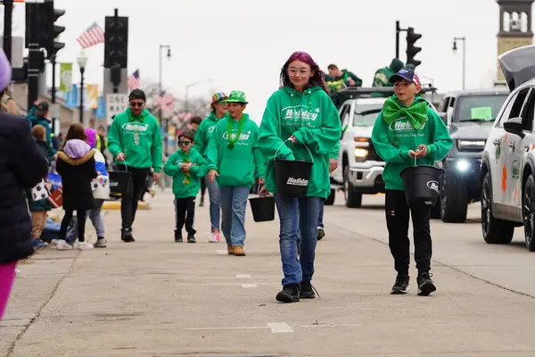 Fond du Lac, Wisconsin ABD - 15 Mart 2025: Cemaat üyeleri ve Yerel Örgütler 2025 St. Patrick Günü Yürüyüşüne katıldı ve çocuklara şeker dağıtarak sokaklarda dolaştı.