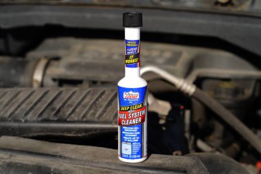 Fond du Lac, Wisconsin USA - 24 Şubat 2025: Bir şişe Lucas Deep Clean Fuel System Cleaner motorun üzerinde oturuyor.