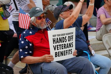 Madison, Wisconsin ABD - 14 Haziran 2025: Çok ırklı insanlar Kralsız etkinlik sırasında protesto pankartları tutuyorlar.