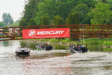 Fond du Lac, Wisconsin USA - 7 Haziran 2025: Mercury tekneleri ile nehirde ve halk parkında gezen insanlar.