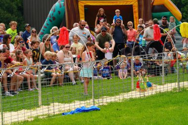 Çocuk çimenlikte bir köpekle zıplıyor..