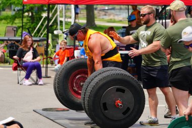 Fond du Lac, Wisconsin USA - 7 Haziran 2025: Spor insanları dışarıda bir halk parkında çalışıyor ve ağırlık kaldırıyor.