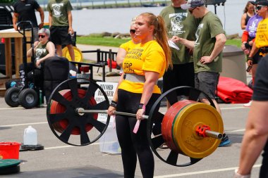 Fond du Lac, Wisconsin USA - 7 Haziran 2025: Kadın ve erkek sporcular dışarıda bir halk parkında ağırlık kaldırıyorlar..