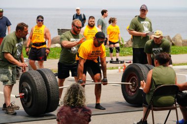 Fond du Lac, Wisconsin USA - 7 Haziran 2025: Kadın ve erkek sporcular dışarıda bir halk parkında ağırlık kaldırıyorlar..