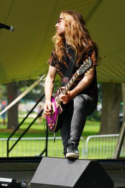 Genç adam konserde elektro gitar çalıyor.