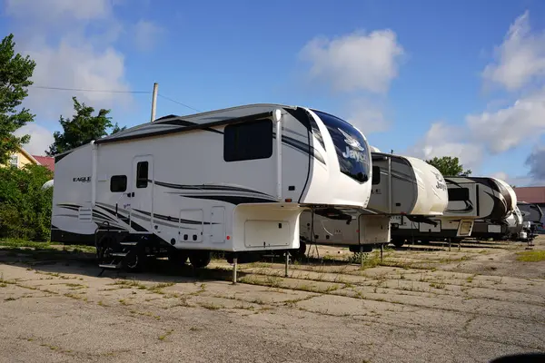 Appleton, Wisconsin USA - August 25th, 2025: Different brands of 5th wheel campers sit outside being stored for the season.