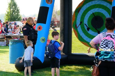 Tomah, Wisconsin ABD - 5 Ağustos 2025: Yerel Polis, Şerif ve İtfaiyeci memurlar, Ulusal Gece Gezisi Aile Eğlencesi etkinliği için cemaat aileleriyle bir araya geldi.