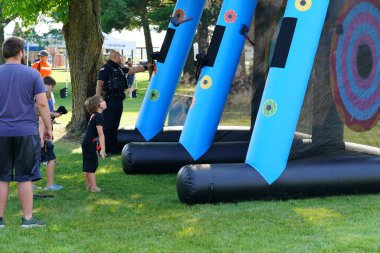 Tomah, Wisconsin ABD - 5 Ağustos 2025: Yerel Polis, Şerif ve İtfaiyeci memurlar, Ulusal Gece Gezisi Aile Eğlencesi etkinliği için cemaat aileleriyle bir araya geldi.