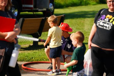 Tomah, Wisconsin ABD - 5 Ağustos 2025: Yerel Polis, Şerif ve İtfaiyeci memurlar, Ulusal Gece Gezisi Aile Eğlencesi etkinliği için cemaat aileleriyle bir araya geldi.