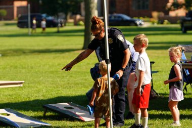 Tomah, Wisconsin ABD - 5 Ağustos 2025: Yerel Polis, Şerif ve İtfaiyeci memurlar, Ulusal Gece Gezisi Aile Eğlencesi etkinliği için cemaat aileleriyle bir araya geldi.