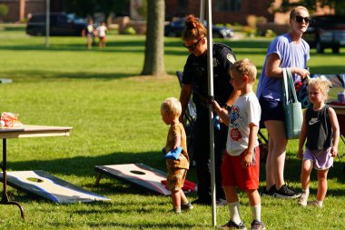 Tomah, Wisconsin ABD - 5 Ağustos 2025: Yerel Polis, Şerif ve İtfaiyeci memurlar, Ulusal Gece Gezisi Aile Eğlencesi etkinliği için cemaat aileleriyle bir araya geldi.