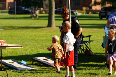 Tomah, Wisconsin ABD - 5 Ağustos 2025: Yerel Polis, Şerif ve İtfaiyeci memurlar, Ulusal Gece Gezisi Aile Eğlencesi etkinliği için cemaat aileleriyle bir araya geldi.