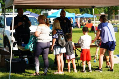 Tomah, Wisconsin ABD - 5 Ağustos 2025: Yerel Polis, Şerif ve İtfaiyeci memurlar, Ulusal Gece Gezisi Aile Eğlencesi etkinliği için cemaat aileleriyle bir araya geldi.