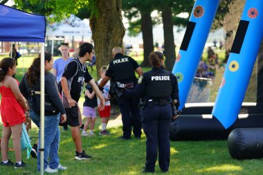 Tomah, Wisconsin ABD - 5 Ağustos 2025: Yerel Polis, Şerif ve İtfaiyeci memurlar, Ulusal Gece Gezisi Aile Eğlencesi etkinliği için cemaat aileleriyle bir araya geldi.