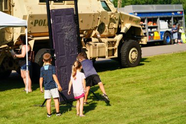 Tomah, Wisconsin ABD - 5 Ağustos 2025: Yerel Polis, Şerif ve İtfaiyeci memurlar, Ulusal Gece Gezisi Aile Eğlencesi etkinliği için cemaat aileleriyle bir araya geldi.