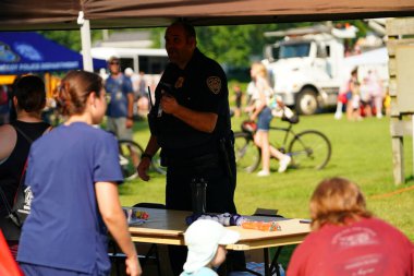 Tomah, Wisconsin ABD - 5 Ağustos 2025: Yerel Polis, Şerif ve İtfaiyeci memurlar, Ulusal Gece Gezisi Aile Eğlencesi etkinliği için cemaat aileleriyle bir araya geldi.
