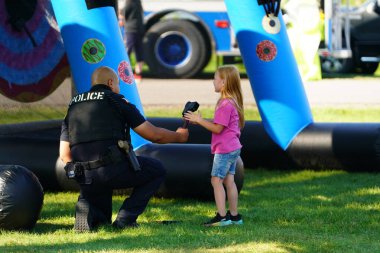 Tomah, Wisconsin ABD - 5 Ağustos 2025: Yerel Polis, Şerif ve İtfaiyeci memurlar, Ulusal Gece Gezisi Aile Eğlencesi etkinliği için cemaat aileleriyle bir araya geldi.