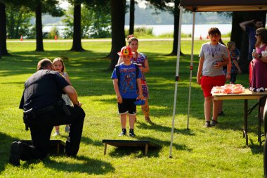 Tomah, Wisconsin ABD - 5 Ağustos 2025: Yerel Polis, Şerif ve İtfaiyeci memurlar, Ulusal Gece Gezisi Aile Eğlencesi etkinliği için cemaat aileleriyle bir araya geldi.