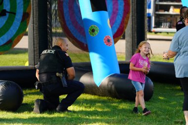 Tomah, Wisconsin ABD - 5 Ağustos 2025: Yerel Polis, Şerif ve İtfaiyeci memurlar, Ulusal Gece Gezisi Aile Eğlencesi etkinliği için cemaat aileleriyle bir araya geldi.