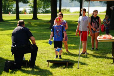 Tomah, Wisconsin ABD - 5 Ağustos 2025: Yerel Polis, Şerif ve İtfaiyeci memurlar, Ulusal Gece Gezisi Aile Eğlencesi etkinliği için cemaat aileleriyle bir araya geldi.