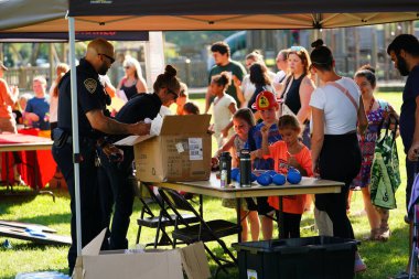 Tomah, Wisconsin ABD - 5 Ağustos 2025: Yerel Polis, Şerif ve İtfaiyeci memurlar, Ulusal Gece Gezisi Aile Eğlencesi etkinliği için cemaat aileleriyle bir araya geldi.