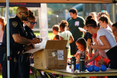 Tomah, Wisconsin ABD - 5 Ağustos 2025: Yerel Polis, Şerif ve İtfaiyeci memurlar, Ulusal Gece Gezisi Aile Eğlencesi etkinliği için cemaat aileleriyle bir araya geldi.