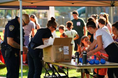 Tomah, Wisconsin ABD - 5 Ağustos 2025: Yerel Polis, Şerif ve İtfaiyeci memurlar, Ulusal Gece Gezisi Aile Eğlencesi etkinliği için cemaat aileleriyle bir araya geldi.