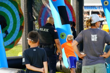 Tomah, Wisconsin ABD - 5 Ağustos 2025: Yerel Polis, Şerif ve İtfaiyeci memurlar, Ulusal Gece Gezisi Aile Eğlencesi etkinliği için cemaat aileleriyle bir araya geldi.