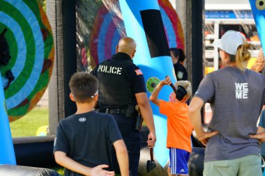 Tomah, Wisconsin ABD - 5 Ağustos 2025: Yerel Polis, Şerif ve İtfaiyeci memurlar, Ulusal Gece Gezisi Aile Eğlencesi etkinliği için cemaat aileleriyle bir araya geldi.