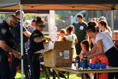 Tomah, Wisconsin ABD - 5 Ağustos 2025: Yerel Polis, Şerif ve İtfaiyeci memurlar, Ulusal Gece Gezisi Aile Eğlencesi etkinliği için cemaat aileleriyle bir araya geldi.