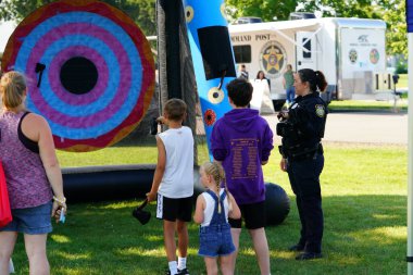 Tomah, Wisconsin ABD - 5 Ağustos 2025: Yerel Polis, Şerif ve İtfaiyeci memurlar, Ulusal Gece Gezisi Aile Eğlencesi etkinliği için cemaat aileleriyle bir araya geldi.