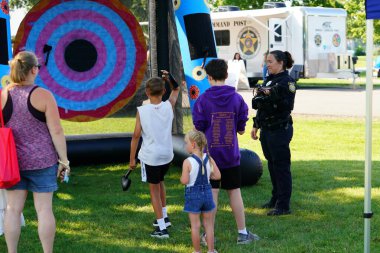 Tomah, Wisconsin ABD - 5 Ağustos 2025: Yerel Polis, Şerif ve İtfaiyeci memurlar, Ulusal Gece Gezisi Aile Eğlencesi etkinliği için cemaat aileleriyle bir araya geldi.