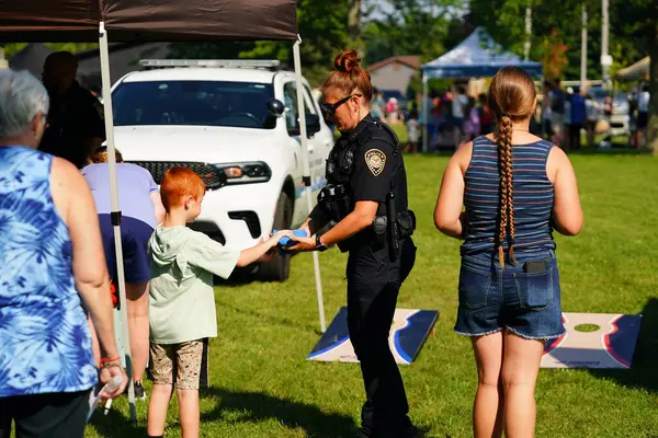 Tomah, Wisconsin ABD - 5 Ağustos 2025: Yerel Polis, Şerif ve İtfaiyeci memurlar, Ulusal Gece Gezisi Aile Eğlencesi etkinliği için cemaat aileleriyle bir araya geldi.
