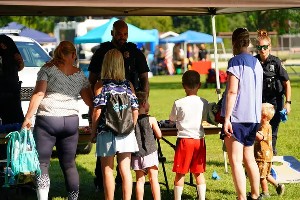 Tomah, Wisconsin ABD - 5 Ağustos 2025: Yerel Polis, Şerif ve İtfaiyeci memurlar, Ulusal Gece Gezisi Aile Eğlencesi etkinliği için cemaat aileleriyle bir araya geldi.