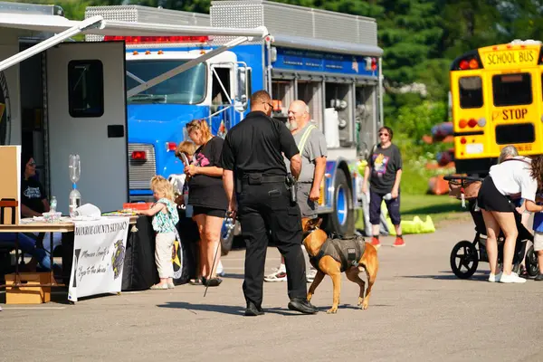 Tomah, Wisconsin ABD - 5 Ağustos 2025: Yerel Polis, Şerif ve İtfaiyeci memurlar, Ulusal Gece Gezisi Aile Eğlencesi etkinliği için cemaat aileleriyle bir araya geldi.