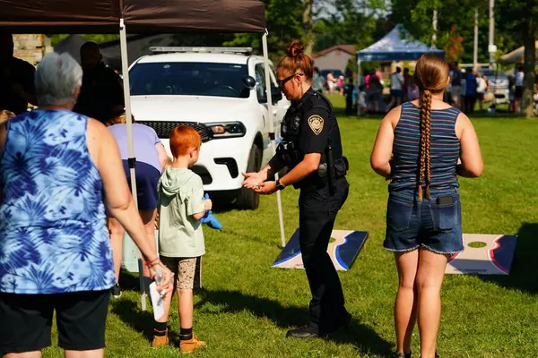 Tomah, Wisconsin ABD - 5 Ağustos 2025: Yerel Polis, Şerif ve İtfaiyeci memurlar, Ulusal Gece Gezisi Aile Eğlencesi etkinliği için cemaat aileleriyle bir araya geldi.