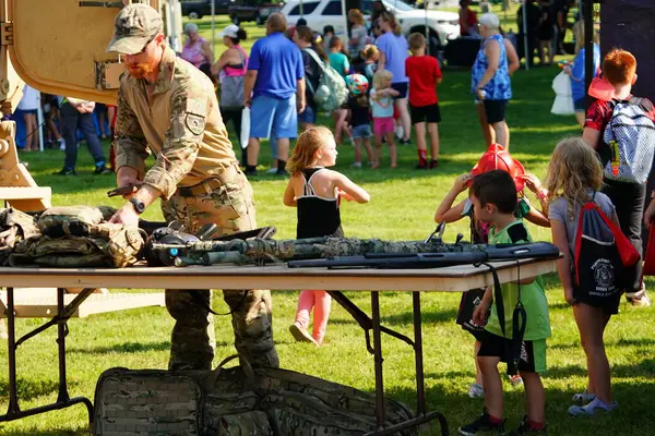 Tomah, Wisconsin ABD - 5 Ağustos 2025: Yerel Polis, Şerif ve İtfaiyeci memurlar, Ulusal Gece Gezisi Aile Eğlencesi etkinliği için cemaat aileleriyle bir araya geldi.