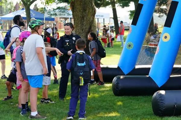Tomah, Wisconsin ABD - 5 Ağustos 2025: Yerel Polis, Şerif ve İtfaiyeci memurlar, Ulusal Gece Gezisi Aile Eğlencesi etkinliği için cemaat aileleriyle bir araya geldi.
